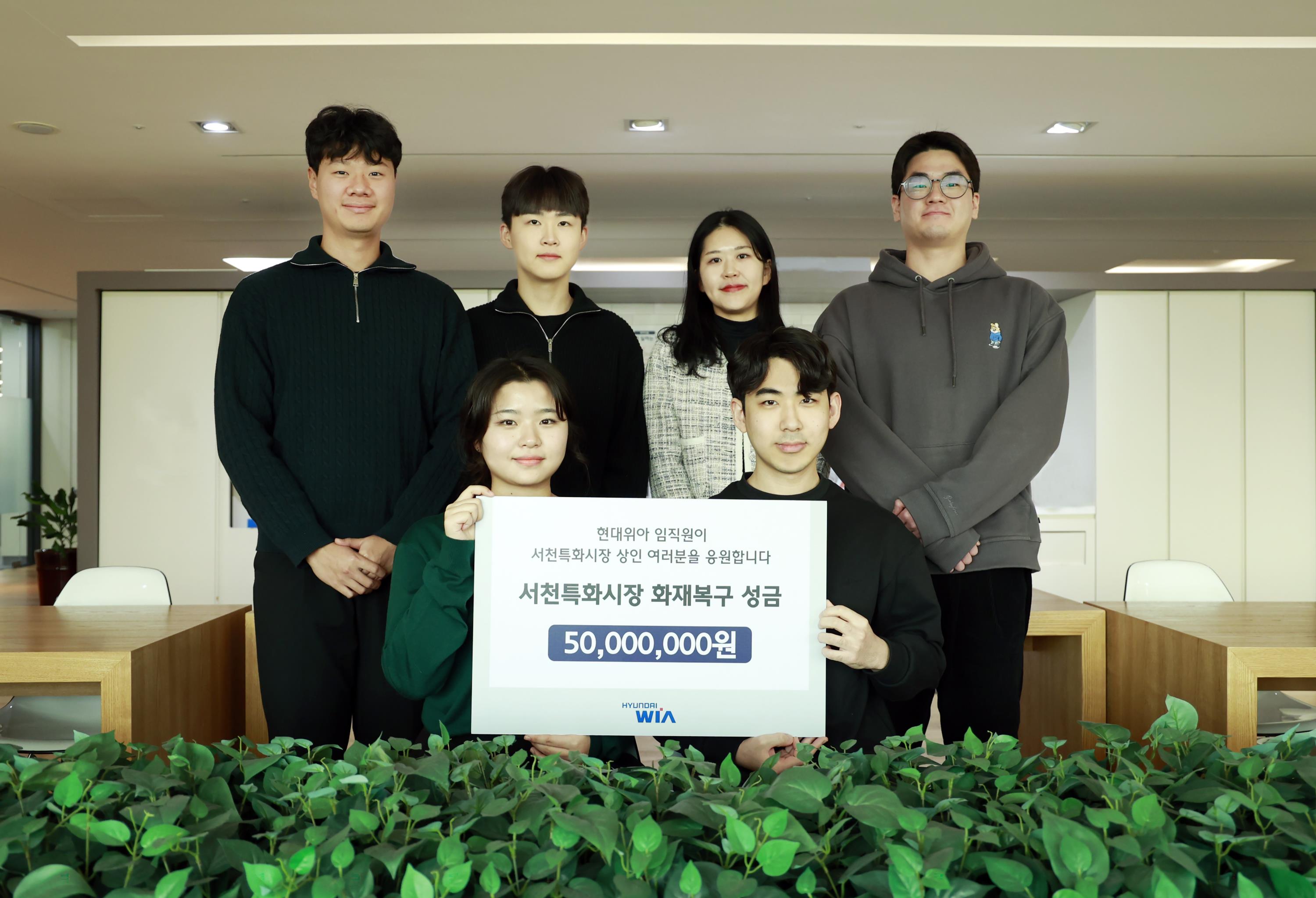 On February 1st, employees of HYUNDAI WIA are taking photos after collecting and delivering ‘Fire Recovery Funds for Seocheon Specialty Market’. HYUNDAI WIA added the company donation of 25 million won to the original 25 million won raised by the employees to help the merchants of Seocheon Specialty Market. Courtesy of HYUNDAI WIA.