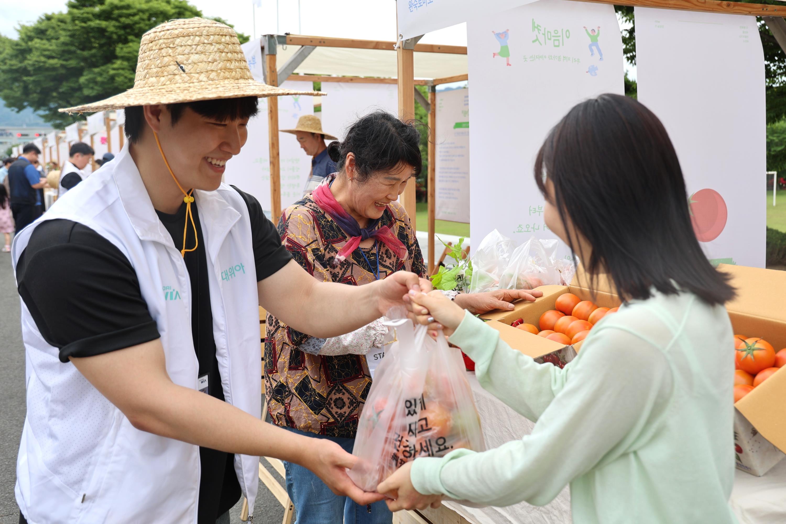 On May 21, a HYUNDAI WIA employee is buying products made by local farmers at the “Yi-Eum Farmers Market” held at HYUNDAI WIA’ s headquarters in Changwon-si, Gyeongsangnam-do.