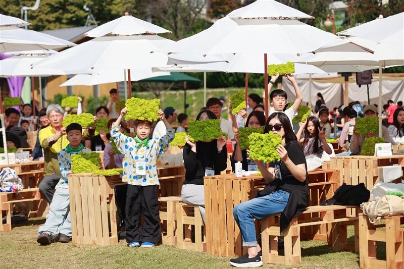 Participated children and parents are holding the "Eco Plant Walls" using Scandiamoss, a plant known for its air-purifying properties. Courtesy of HYUNDAI WIA.